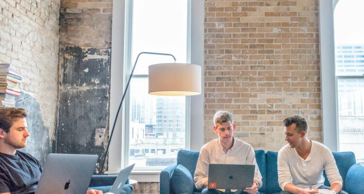 three men using MacBooks